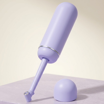 Lavender portable bidet with extended spray wand and matching cap in a premium studio setting