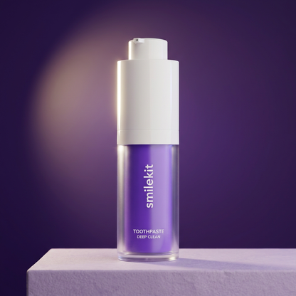Smile Kit purple toothpaste pump bottle on a lilac platform against a deep violet studio background